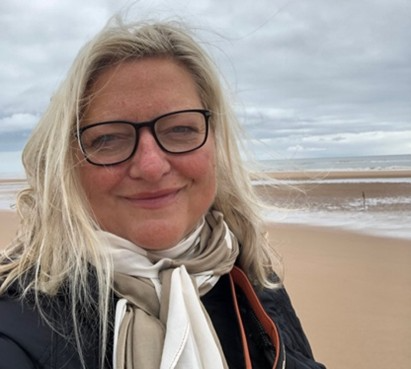 Claire Geddes smiling on a sandy beach, CG Counselling and Coaching, Knutsford, Alderley Edge and Wilmslow.